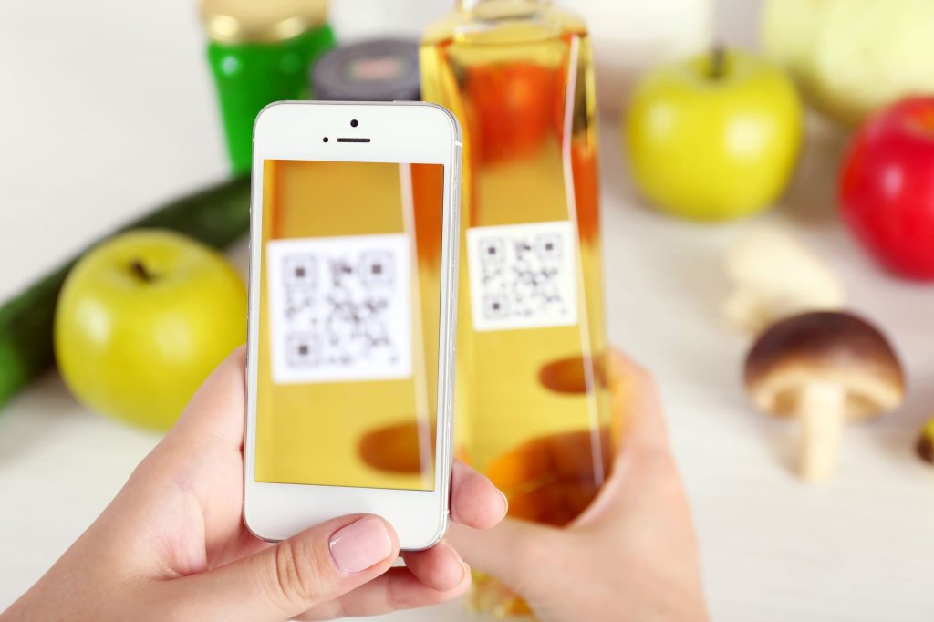 Женская рука держит смартфон и сканирует QR-код